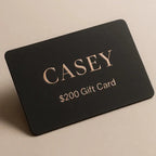 Black gift card with 'CASEY' and '$200 Gift Card' text on a beige background