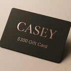 Black gift card with 'CASEY' and '$300 Gift Card' text on a beige background
